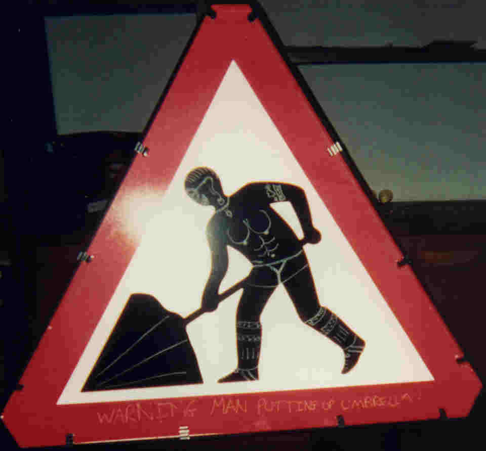 Warning: Man putting up unbrella